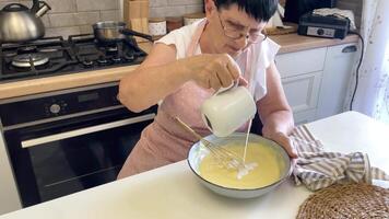 Baker adding milk and whisking ingredients in a bowl video
