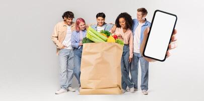 A group of five customers stands together, smiling and enjoying their groceries in a light-filled space. One person holds a smartphone, reflecting a new era of shopping and delivery. photo