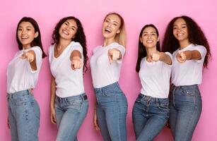 We Choose You. Multicultural Group Of Ladies Pointing Finger At Camera Standing Posing Over Pink Background. Advertisement Banner With Positive Females Point Finger At You. Studio Shot photo