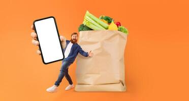 A customer holds a smartphone in one hand while standing next to a large paper bag filled with fresh groceries. This activity highlights the current trend of online grocery shopping and delivery. photo