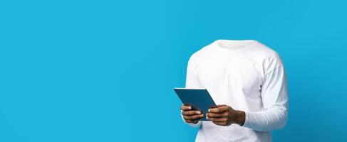 A headless individual stands against a vibrant blue background, engaged with a tablet. This trendy collage highlights a modern, isolated lifestyle, emphasizing seamless digital interaction. photo