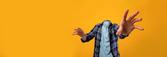 Engaging visual features headless individual extending his arms, set against a bright yellow backdrop. This unique concept highlights the essence of isolation and dynamic lifestyle choices. photo