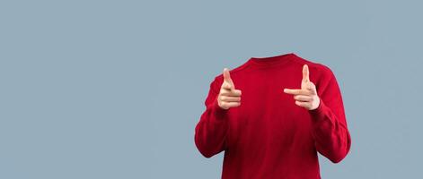 A headless person in a red sweater poses with playful finger gun gestures. The isolated background emphasizes the unique lifestyle concept, creating a striking visual effect for creative projects. photo