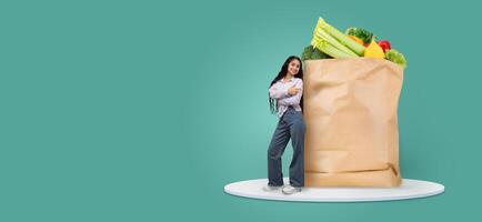 A customer stands next to a large paper bag filled with fresh groceries. She looks pleased with her purchase, symbolizing new shopping habits in a modern market environment. photo