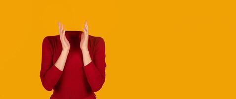A person without a head is seen clapping their hands, dressed in a red long-sleeve top. The bright yellow background creates an isolated, artistic effect suitable for a modern collage. photo