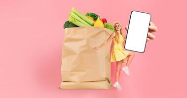 A customer holds a smartphone next to a paper bag filled with fresh produce. The background features a bright, colorful setting, emphasizing the convenience of grocery shopping and delivery. photo