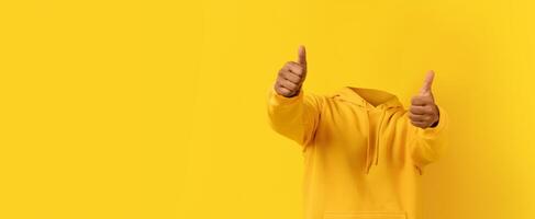 A headless individual in a bright yellow hoodie gives two thumbs up against a vivid yellow background. This collage design emphasizes positivity and fun in a minimalist style. photo