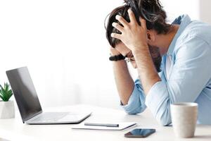 Work Problems. Millennial Freelancer Guy Siting At Desk And Touching Head In Despair, Having Luck Of Inspiration While Working On Laptop At Home Office, Depressed Eastern Man Got Bad News, Copy Space photo