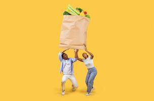 A couple is lifting a large paper grocery bag filled with fresh vegetables and fruits. They are smiling, showcasing the joy of shopping together despite the challenges of today's world. photo