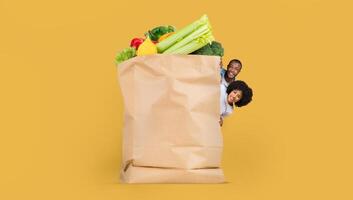 Customers hold a large paper bag filled with fresh vegetables and fruits. This reflects the current trends in grocery shopping, emphasizing remote purchases and delivery methods. photo