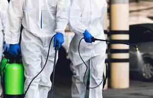 Unrecognizable workers making wet disinfection of streets for prevention coronavirus epidemic, copy space photo