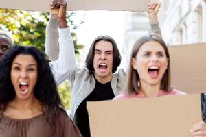 Closeup of furious multiracial millennial protestors with empty placards chanting slogands next to government building on the street, striking against 2021 lockdown restrictions, closeup photo
