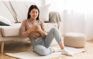 Modern girl checking emails on smartphone, spending time at home and relaxing, free space photo