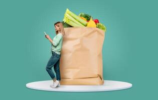 A shopper checks her phone while leaning against a large paper bag filled with fresh produce. The image highlights the new normal of grocery shopping and delivery in a contemporary setting. photo