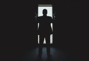 A man in a suit standing in front of a window photo