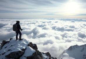A man standing on top of a mountain looking down at clouds photo