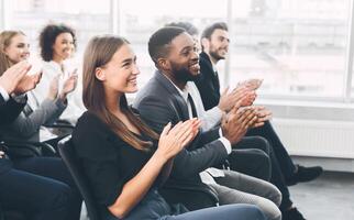 Diverse business team greeting speaker with applause and smiling, free space photo
