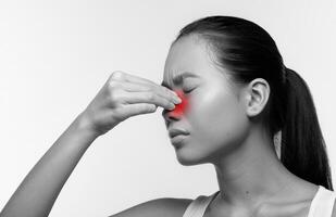 Closeup photo of unhappy young japanese woman with closed eyes rubbing red sore nose, suffering from rhinitis, studio background, black and white photo, panorama with copy space