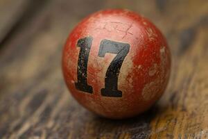 Vintage Red Billiard Ball with Number 17 on Wooden Surface - Rustic Charm for Game Room Decor photo