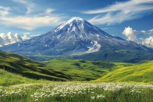 Majestic volcano rises above lush green hills under a vibrant blue sky filled with clouds photo