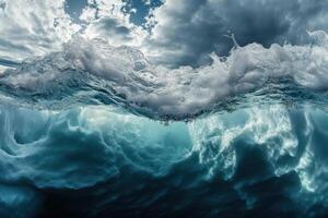 Ocean wave crashing beneath cloudy sky captured from underwater perspective near shoreline photo