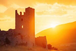 A castle in the sunset with the sun behind it photo