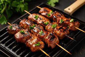 Grilled pork skewers with parsley resting on a grill photo