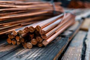 Copper rods resting on wooden planks in warehouse setting photo