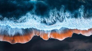 Ocean waves crashing on black sand beach creating orange foam lines photo