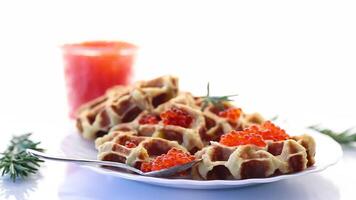Potato waffles with red caviar on a white background video