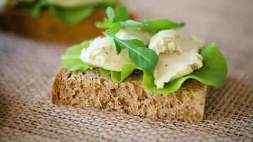 Appetizing sandwich with greens and fish spread on a burlap tablecloth video