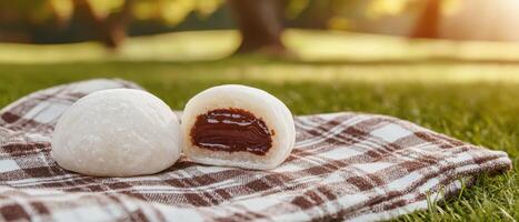 Enjoying homemade mochi with chocolate filling in a sunlit park outdoor food photography photo