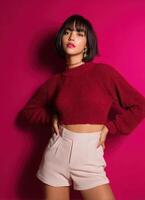 Fashion portrait of a model posing elegantly against a vibrant pink background photo