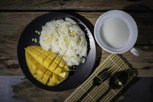 Mango Sticky Rice, Thai food, with an old wooden backdrop. photo