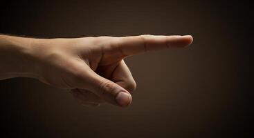 A hand pointing at something on a dark background photo