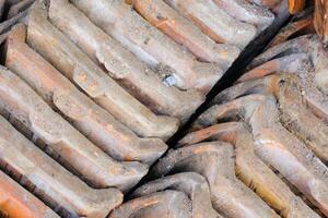 Mossy roof tiles. A collection of backgrounds of dismantled roof tiles replaced with new roof tiles. Abstract textured wallpaper backgrounds. Texture and details. Copy space photo
