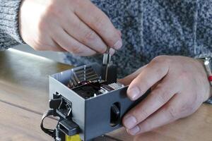 Man dismantling an electrical component for repair, printer photo