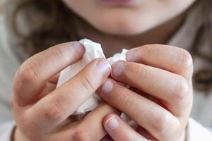Child with a handkerchief in his hands, authentic activity, allergy, illness, cold, rhinitis, cold photo