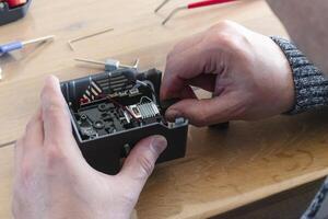 Man dismantling an electrical component for repair, 3d photo