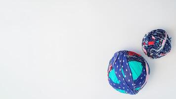 Rag balls of different fabrics on a white background. Flat lay, copy space. Recycled material from T-shirts for knitting rugs. photo