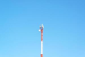 Mobile tower of cellular, radio and internet communications against the background of a clear blue sky photo