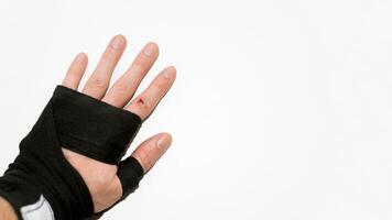 Open wound on the finger. Palm in boxing bandage on a white background, copy space. Training trauma. Injury sport concept. photo