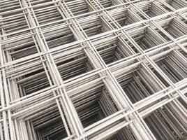 Optical illusion photo of stack of wire mesh iron. A group of cast iron forms a rectangle with three-dimensional depth. Construction Industry. Hardware and building materials store. Text Space