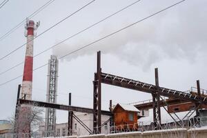 Old factory, rusty structures and a smoking chimney. Air pollution. Russia, Smolensk 01.23.2021 photo