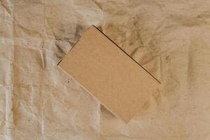 Cardboard box on crumpled craft paper. Flat lay. Delivery concept photo