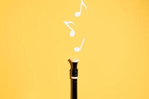 Musical flute and notes, flat lay on a yellow background. Copy space photo