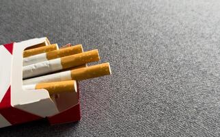 Cigarettes Lined Up in Open Pack on White Surface photo