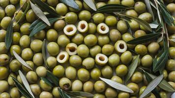 A large pile of green olives with leaves photo
