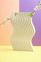 Minimalistic composition featuring a textured wavy concrete stand with blossoming branches. A modern and creative design element. photo