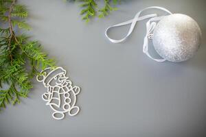 Snowy New Year's ball, thuja and snowman on a gray background photo